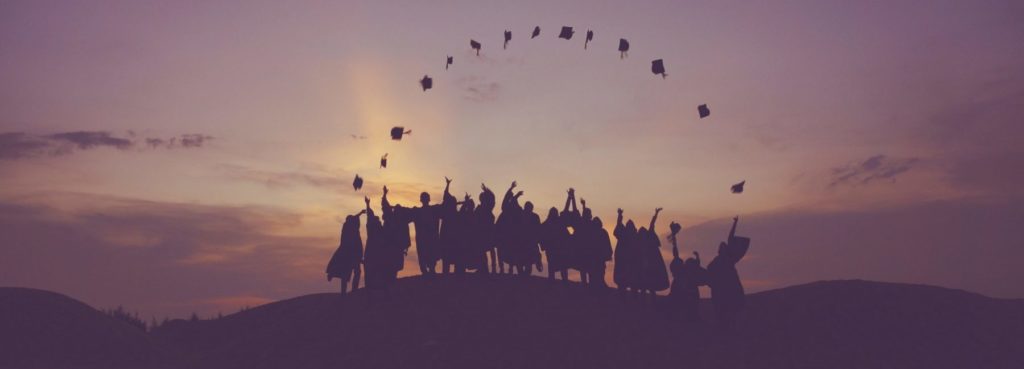 Graduates celebrate on a hilltop