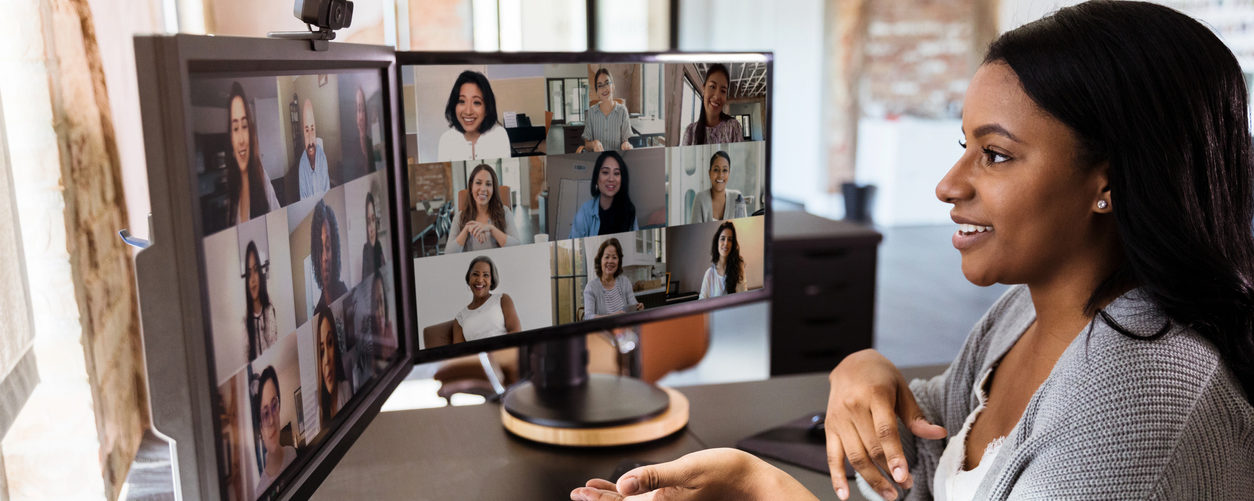 woman working remotely on video call with diverse coworkers