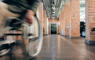 Wheelchair speeding through brick hallway.
