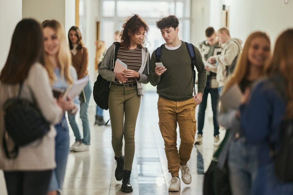 Two students using AI queries and receiving answers that highlight schools using AI optimization for higher ed