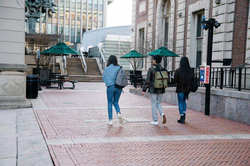 Three students walking on a college campus.