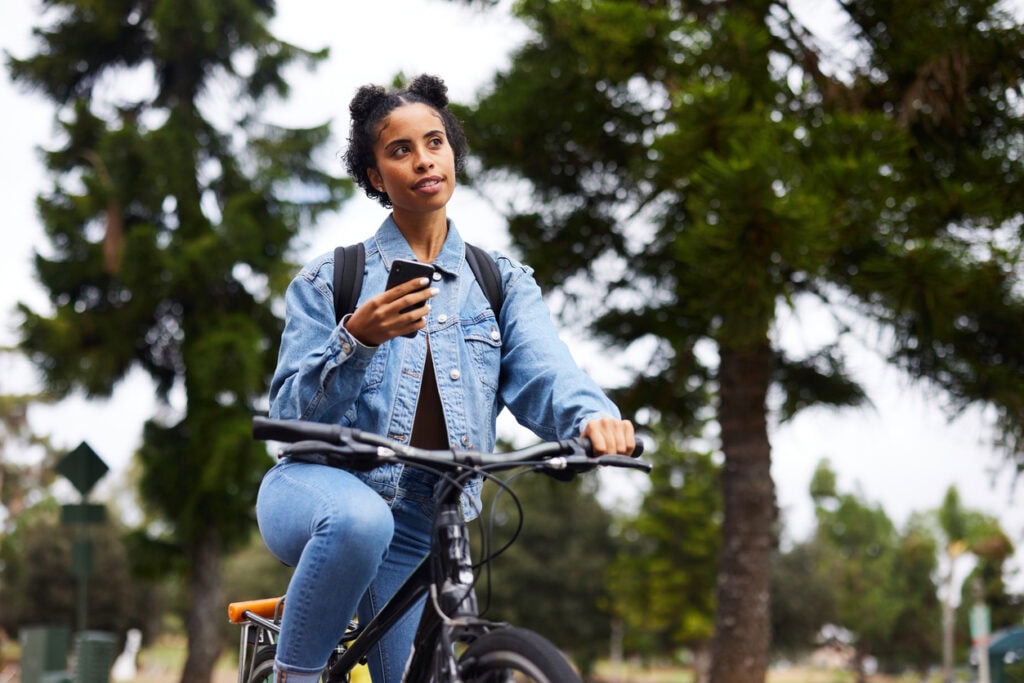 Student using a campus app with data integrations and interactive campus maps to safely navigate on a bike