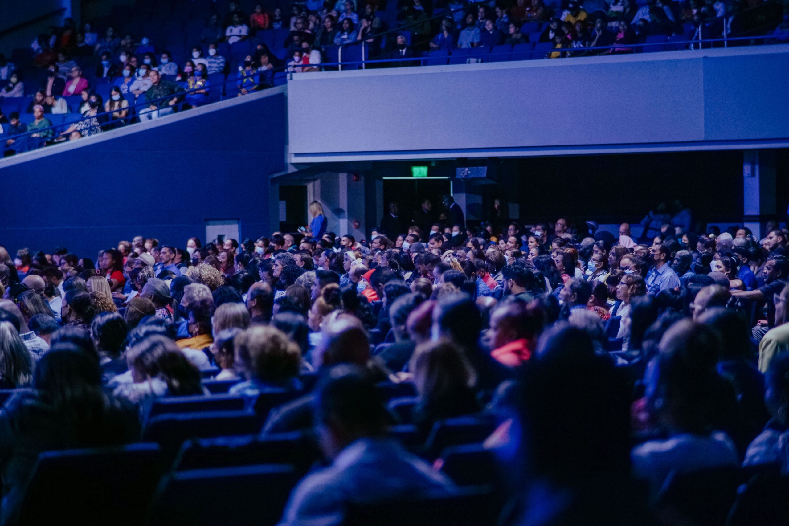 people in a blue lit convention room