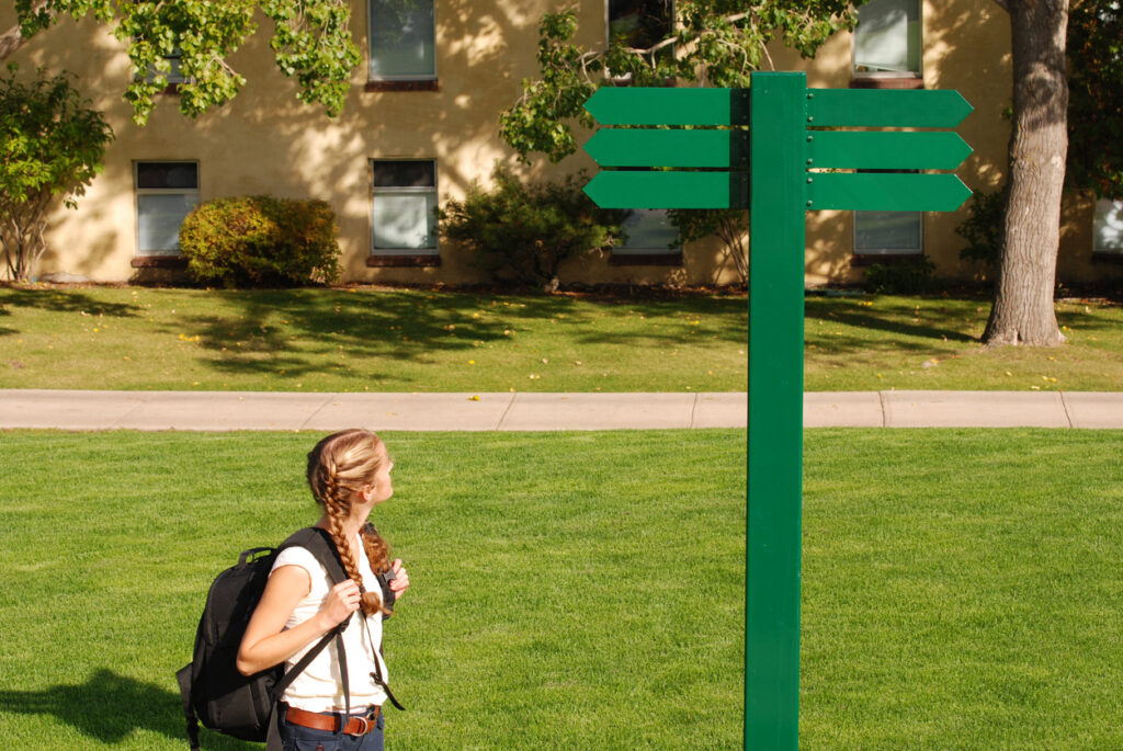 Student using physical campus navigation signs