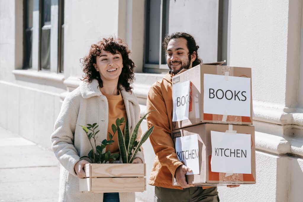 A couple carrying boxes to move into new dorm.