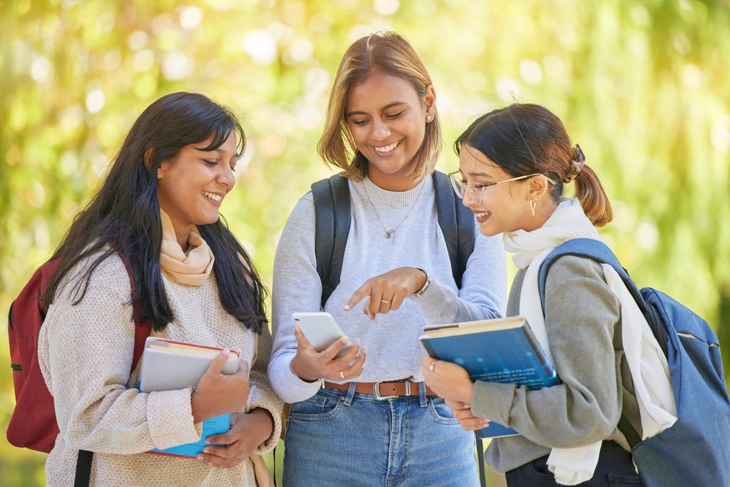 Friends in high school exploring a college website together